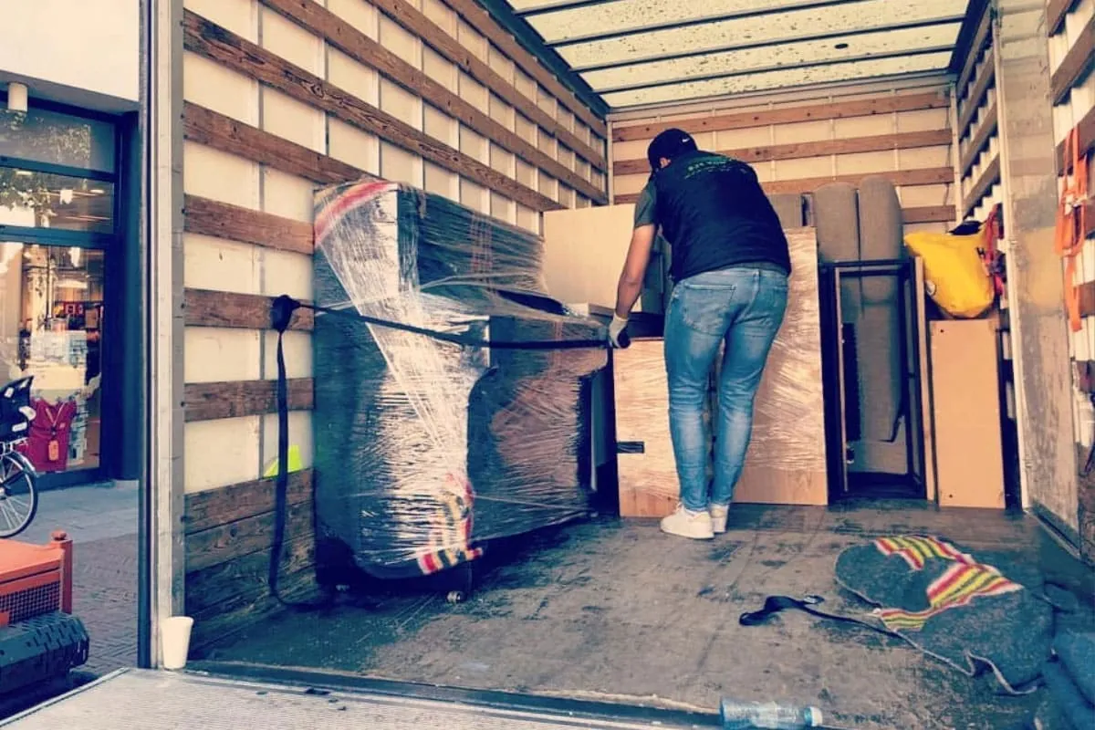 Zorgvuldig ingepakt meubilair wordt in de verhuiswagen van Busje komt zo geladen
