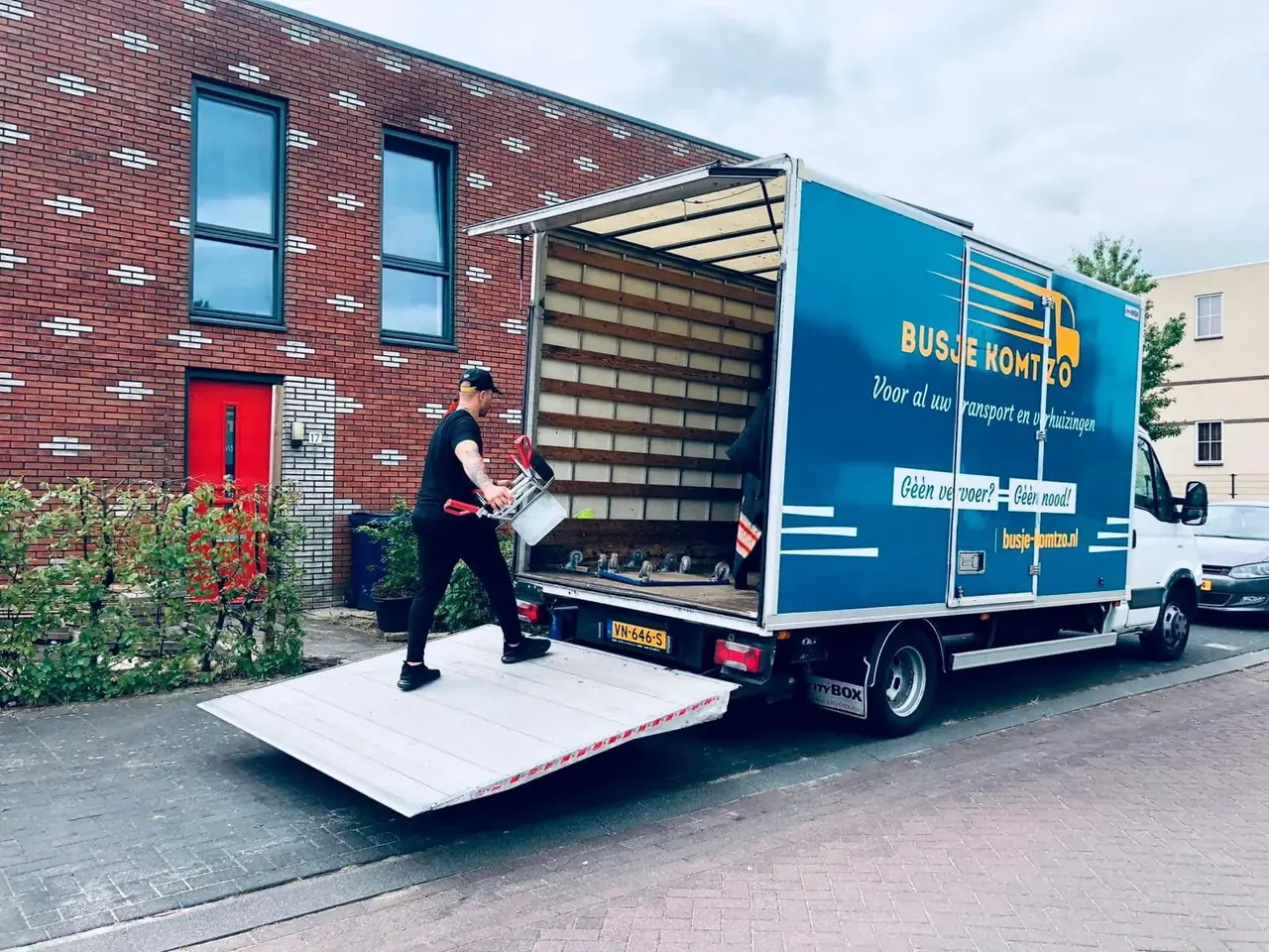 Verhuizer van Busje komt zo laadt spullen via de laadklep in de verhuiswagen